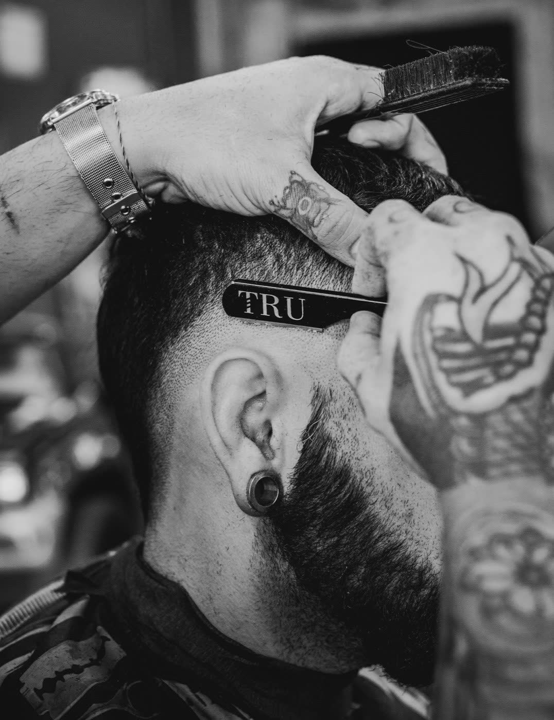 Barbero perfilando un degradado con peine y navaja